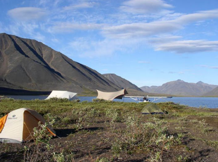 Arctic Tundra area with tents in the valley of mountains